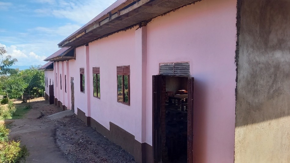 St Agnes Secondary School classroom block in its completed state - it has pink paint and its set in lush green grounds